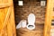 A simple village toilet with a huge roll of toilet paper.Large roll of toilet paper in the toilet