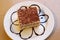 Simple white dish with large slice of flavorful Tiramisu, a drizzle of chocolate sauce for decoration