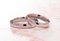 Simple White Gold Wedding Rings on a Pink Table