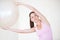 Simple whole-body workout. a young woman with her arms stretched above her head holding an exercise ball.