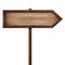 Simple wooden arrow signpost roadsign made of natural wood with single pole and dark frame