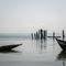 Simple wooden boats moored at timber logs at harbor of Bubaque island, Bijagos Archipelago, Guinea Bissau