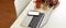 Simple workspace with laptop, smartphone, stationery, stack of books and mug on white desk