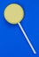 Simple yellow lollipop isolated on blue background.