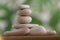 Simplicity stones cairns on green and white background, group of light gray pebbles built in tower, wood table