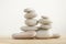 Simplicity stones cairns  on white background, group of light gray pebbles built in towers, wood table