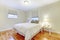 Simplistic white and brown bedroom interior with hardwood floor