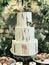 Simply decorated three-layered wedding cake with white cream and flowers.