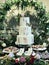 Simply decorated three-layered wedding cake with white cream and flowers.
