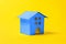 Simply design with toy house colored in trendy color of year 2020 Classic Blue isolated on yellow background. Mortgage property