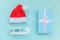 Simply minimal composition winter objects ornament Santa hat sled gift box isolated on blue pastel trendy background