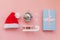 Simply minimal composition winter objects ornament Santa hat sled gift box isolated on pink pastel trendy background
