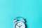 Simply minimal design ringing twin bell vintage classic alarm clock Isolated on blue pastel background. Rest hours time of life