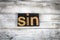 Sin Letterpress Word on Wooden Background