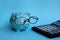 Sinaja piggy bank wearing glasses stands by a calculator