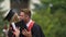 Sincere emotions of cheerful male and female graduates hugging and laughing