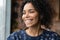 Sincere smiling young african american woman looking in distance.