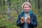 A sincerely smiling woman demonstrates the mushrooms collected in the forest. Picking up fresh organic mushrooms. Finland