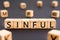 Sinful - word from wooden blocks with letters