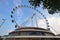 Singapore Flyer with tree leaves and merchandise shop building below