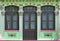 Singapore Straits Chinese Peranakan shophouse with lime green exterior, arched windows, brown louvred shutters & pink trimmings  