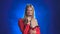 Singer in a red dress is singing into a retro microphone. Smoke background