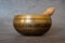 Singing bowl close-up, soothing and meditative. Singing bowl with sanskrit engraving pattern and wooden mallet  on gray