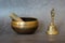 Singing bowl and golden bell close-up, soothing and meditative. Singing bowl with sanskrit engraving pattern and wooden mallet and