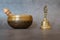 Singing bowl and golden bell close-up, soothing and meditative. Singing bowl with sanskrit engraving pattern and wooden mallet and