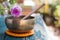 Singing bowl on a rustic wooden table with flowers, zen, outdoors