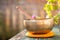 Singing bowl on a rustic wooden table with flowers, zen, outdoors