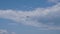 Single airplane flying in a cloudy bright sky