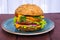 Single american burger with cheddar cheese, meat and fresh vegetables