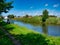 A single angler fishes for carp on the Leeds Liverpool Canal with a long carbon fibre pole that reaches across the water.