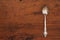 Single antique silver spoon on an empty wooden table with a copy space