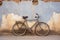 single bicycle leaned against a rustic wall