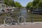 A single bicycle leaning against a railing, overlooking a canal in Amsterdam