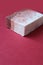 Single block of home made soap on dark red background