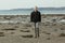 Single blond boy walking on beach outside