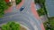 Single blue car is driving across curved intersection in city, aerial view