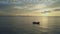 Single Boat Sails in Ocean against Sun Path at Dawn
