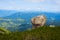 Single boulder on the background of the green valley