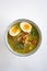 A single bowl of Soto Ayam (translation: Indonesian chicken soup) from above on a white background