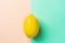Single Bright Ripe Yellow Lemon on Contrast Background from Combination of Pink Peachy Turquoise Background. Styled Creative Image
