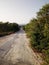 Single broken road between the forest going till beach