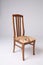 Single brown chair with soft seat and carved back on an isolated