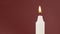 A Single Candle is Lit on a Green Background. Lighting. Candle Flame