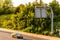 Single car on uk motorway road under information display at sunset