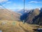 Single Chair Cableway in motion. The beautiful landscape of snowy high mountains Caucasus Elbrus is clearly visible from it.
