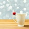 Single cherry on cup handle on bokeh background